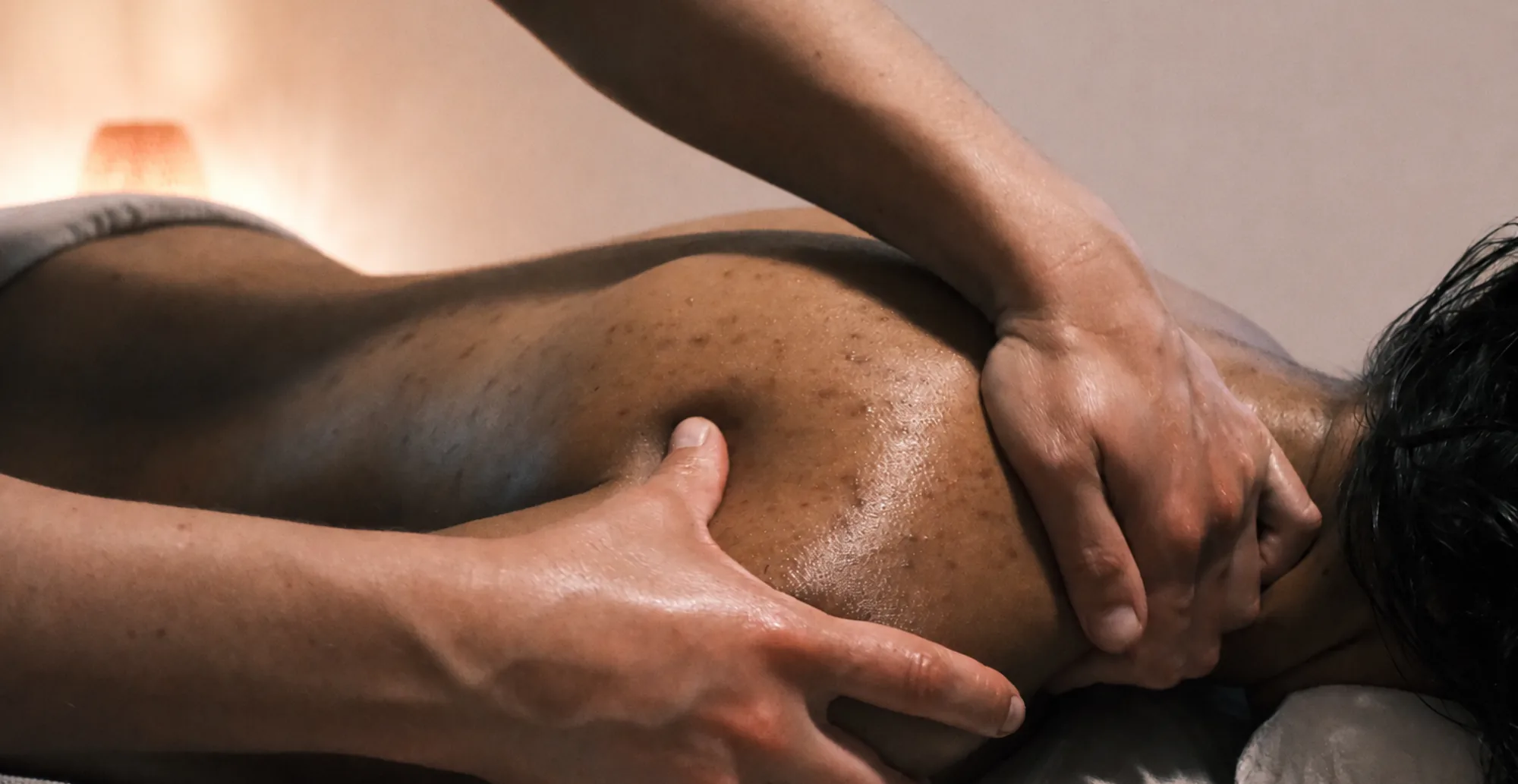 Massage bien-être à l'huile, geste précis, ambiance chaleureuse