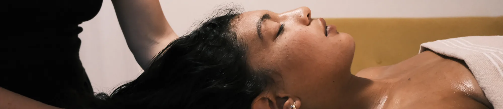 Cliente allongée pendant la relaxation crânienne, visage détendu